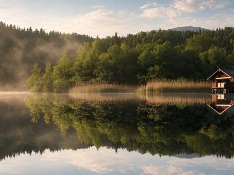 Idyllische Hütte am ruhigen See – Leinwandbild